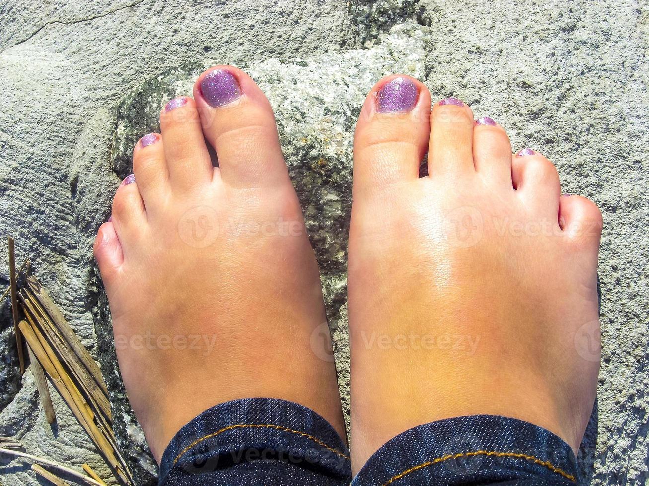 Women girl feet with painted nails in nature on stones. photo