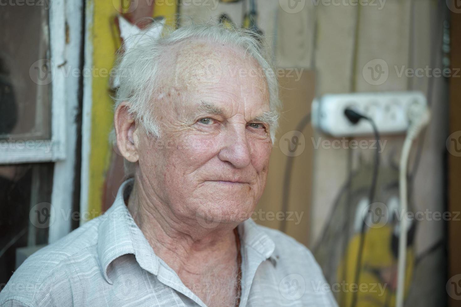 Handsome gray-haired elderly man looking at the camera. Pensioner close-up. photo