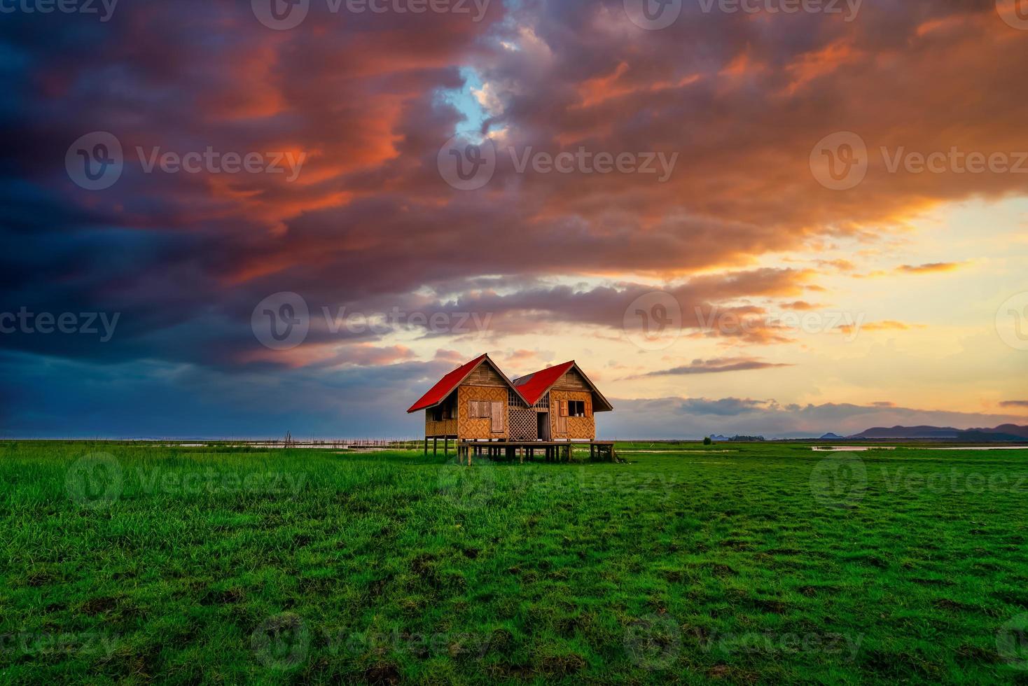 Landscape image of Abandoned twin house near Chalerm Phra Kiat road at sunset in Thale Noi, Phatthalung, Thailand photo