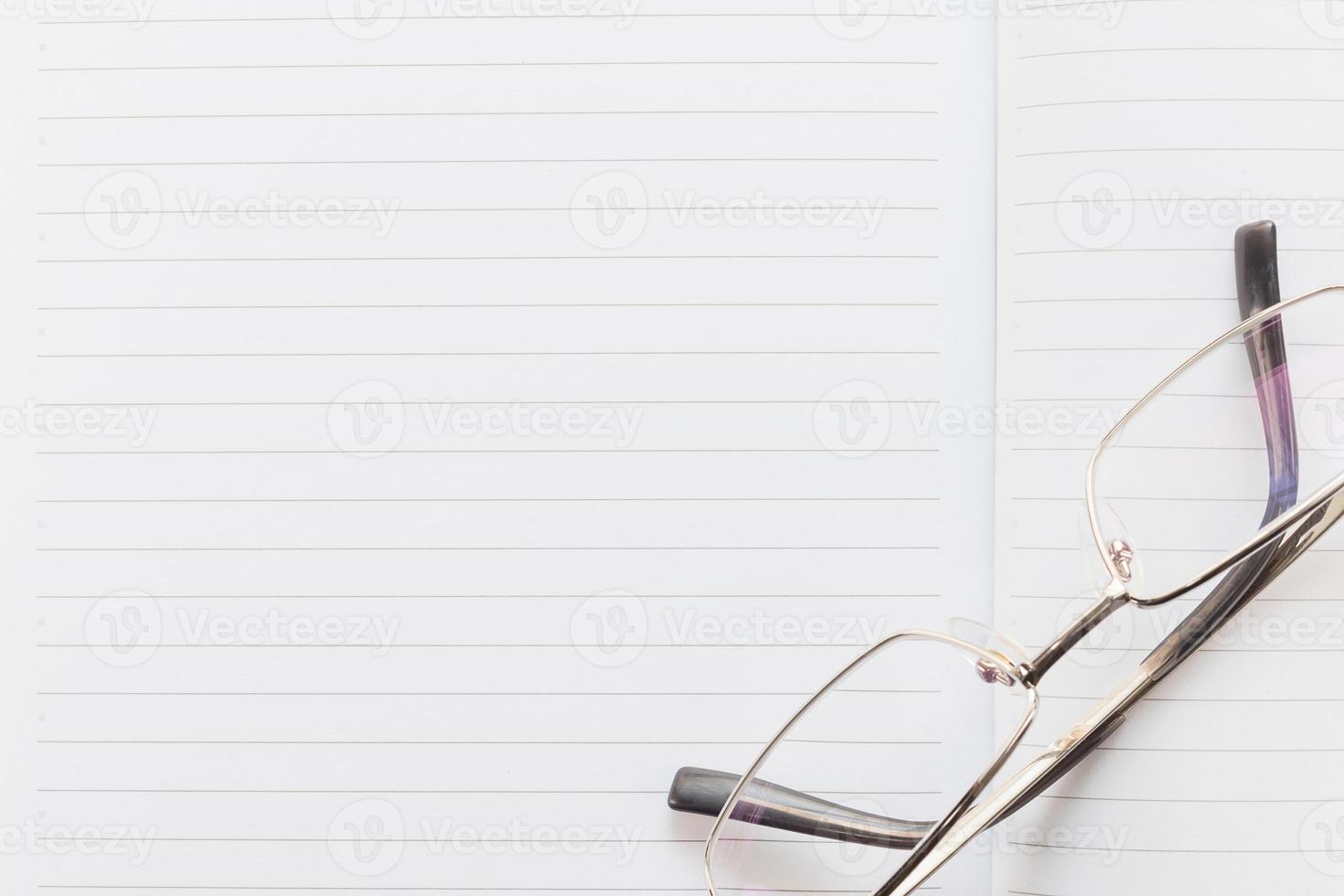 Notebook open blank page and Eyeglasses photo