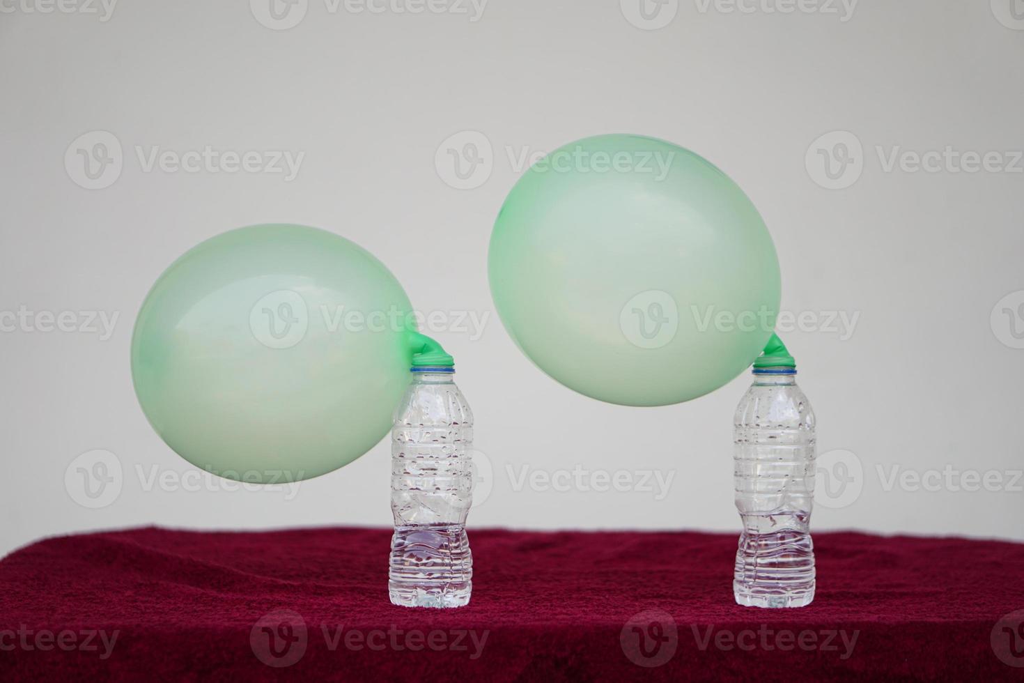 Green inflated balloons on top of transparent test bottles. Concept, science experiment about reaction of chemical substance, vinegar and baking soda that cause balloon inflat. Last step of experiment photo