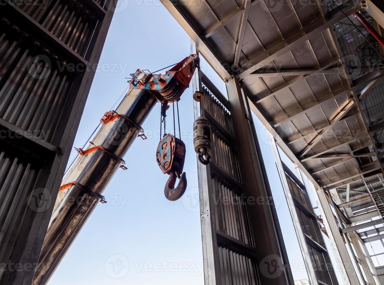 Hoist of crane at the window of industrial plant photo