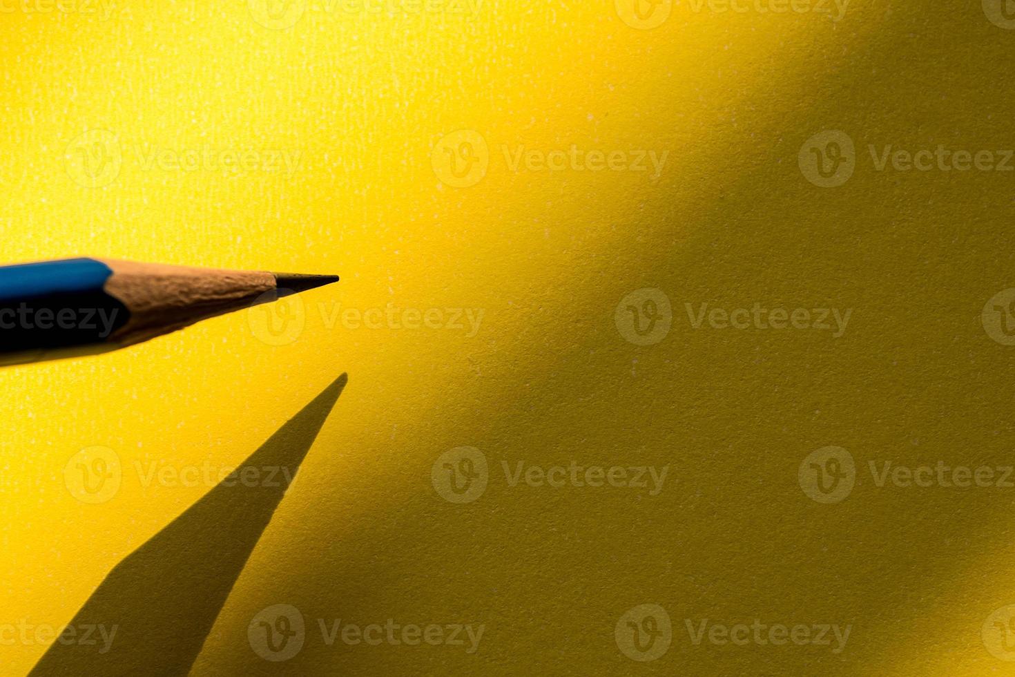lápiz sosteniendo para escribir en el papel en la sombra foto