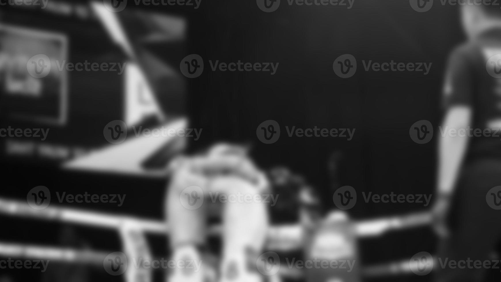 Blurred images black and white photo style of Thai boxing or Muay Thai or Kickboxing which local and foriegn boxer are fighting on the ring at indoor stage as martial art sport. Muay Thai Kick boxing