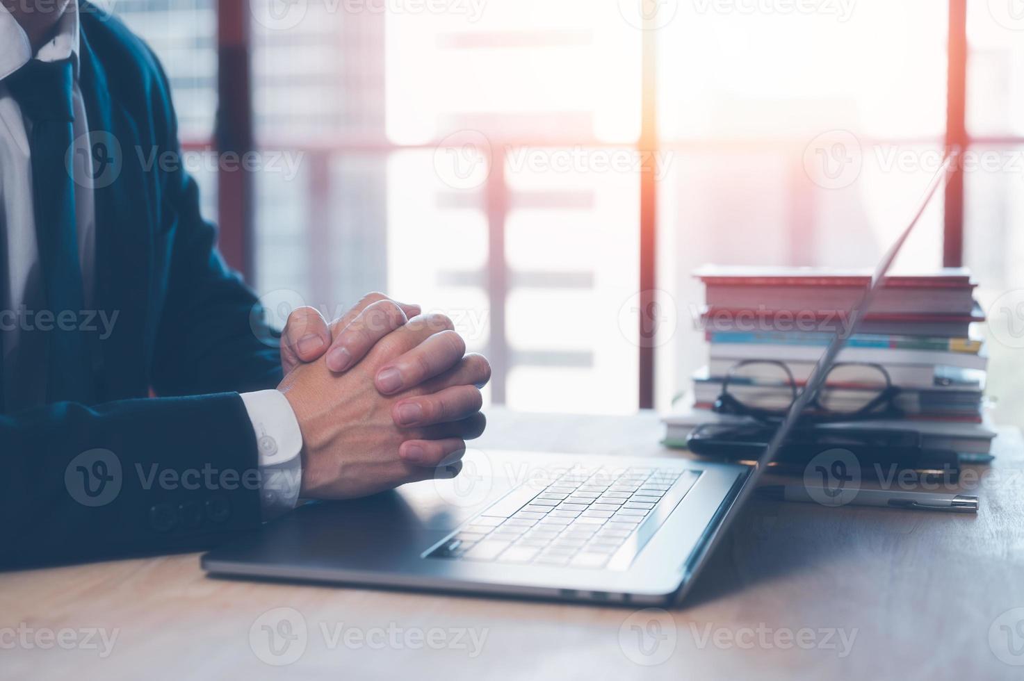 Hand praying with laptop, Church online Sunday services concept, Hands folded in prayer concept for faith. businessman folded hands to make some decision photo