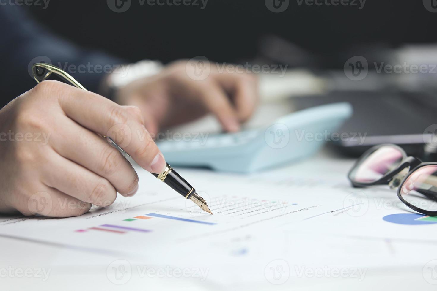 Male hand doing accounting, calculating bills, and expenses at home. Family budget bill payment checklist concept, pay bill check, income allocation plan, or Family budget hedge plan. photo