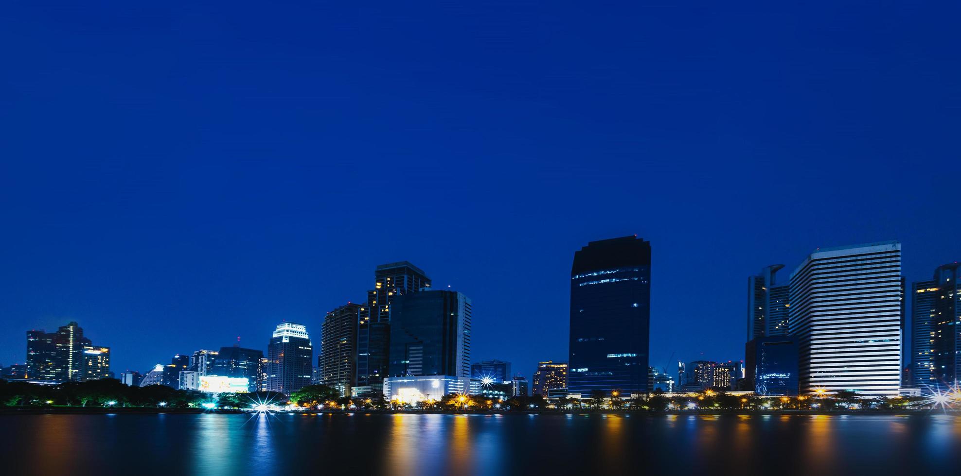 Night view of skyscrapers with river in business district of the capital city in Bangkok, Thailand. with copy space and text design for business photo