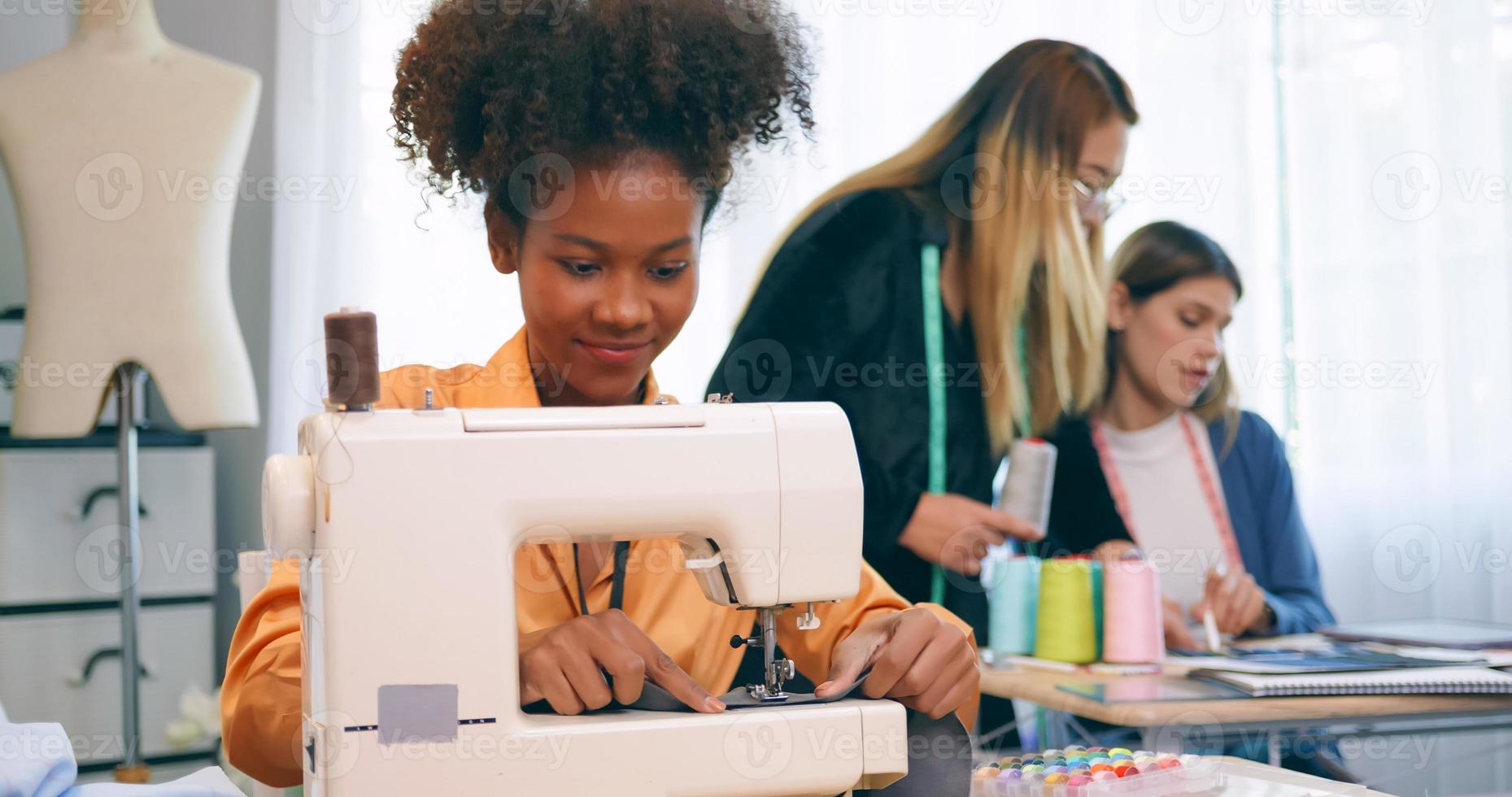 A group of young women are learning the profession of design and tailoring. photo