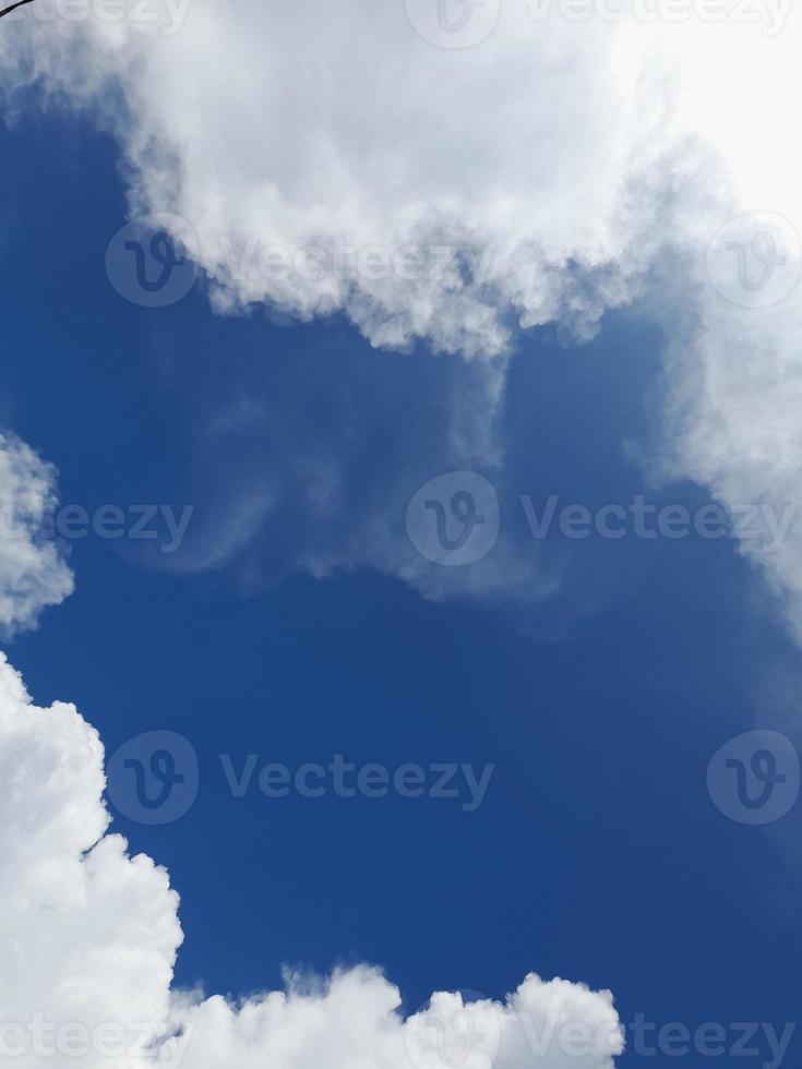 Beautiful white clouds on deep blue sky background. Large bright soft fluffy clouds are cover the entire blue sky. photo