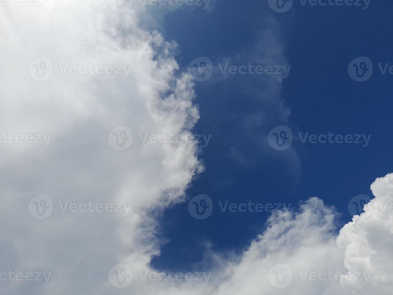 Beautiful white clouds on deep blue sky background. Large bright soft fluffy clouds are cover the entire blue sky. photo