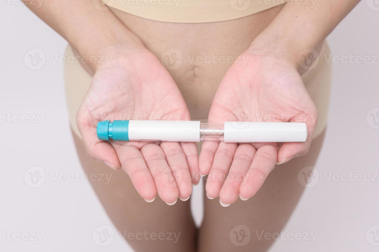Close up woman using IVF treatment injection on belly to prepare reproductive fertility , Ovulation stimulation . photo