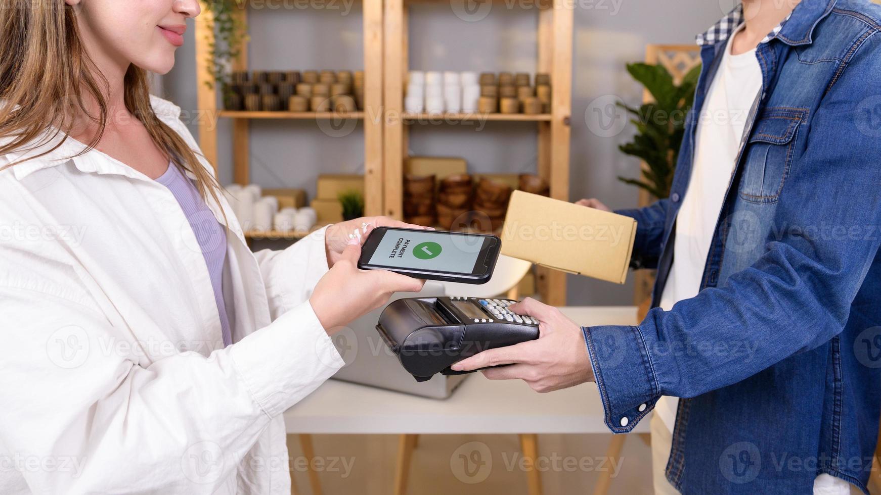 woman customer using QR code payment via smartphone for paying at shop photo