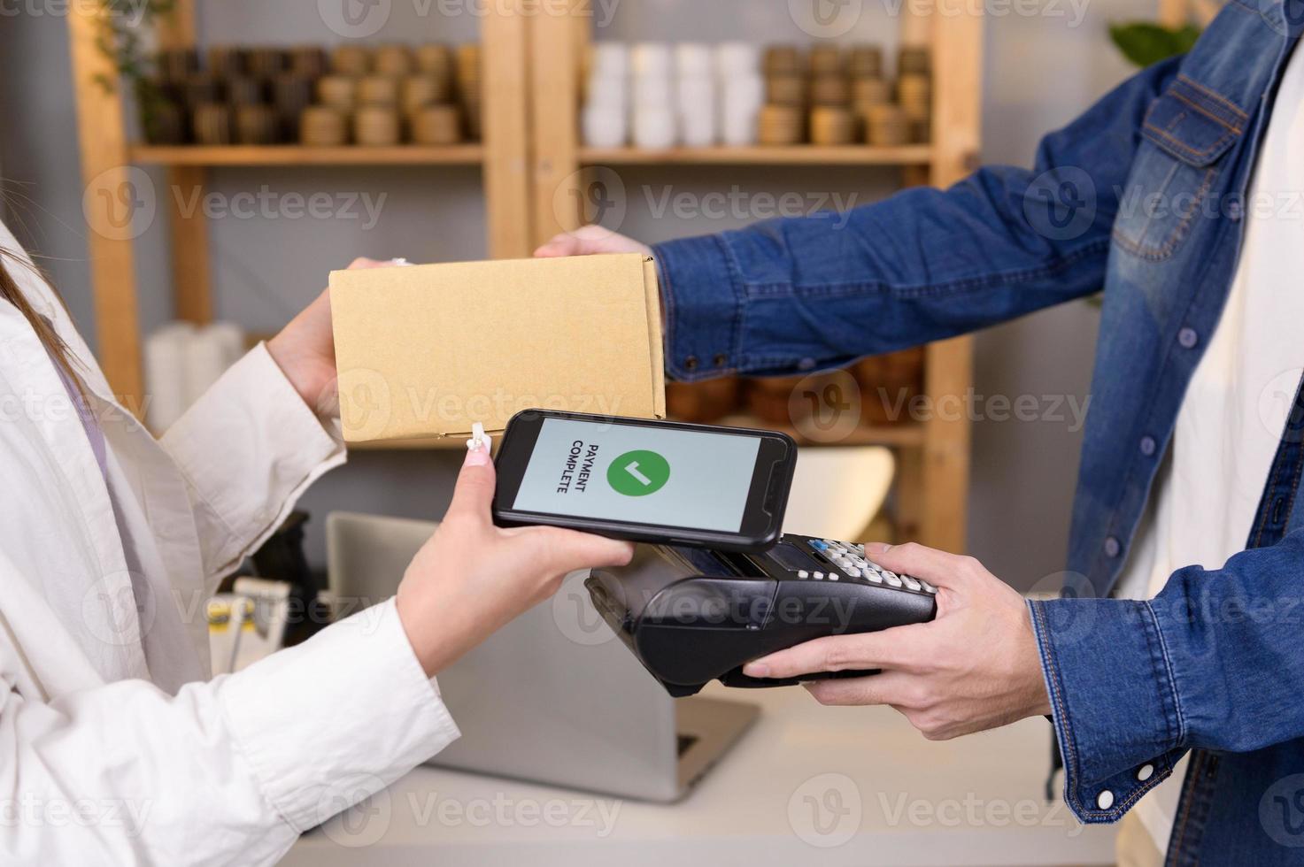 woman customer using QR code payment via smartphone for paying at shop photo