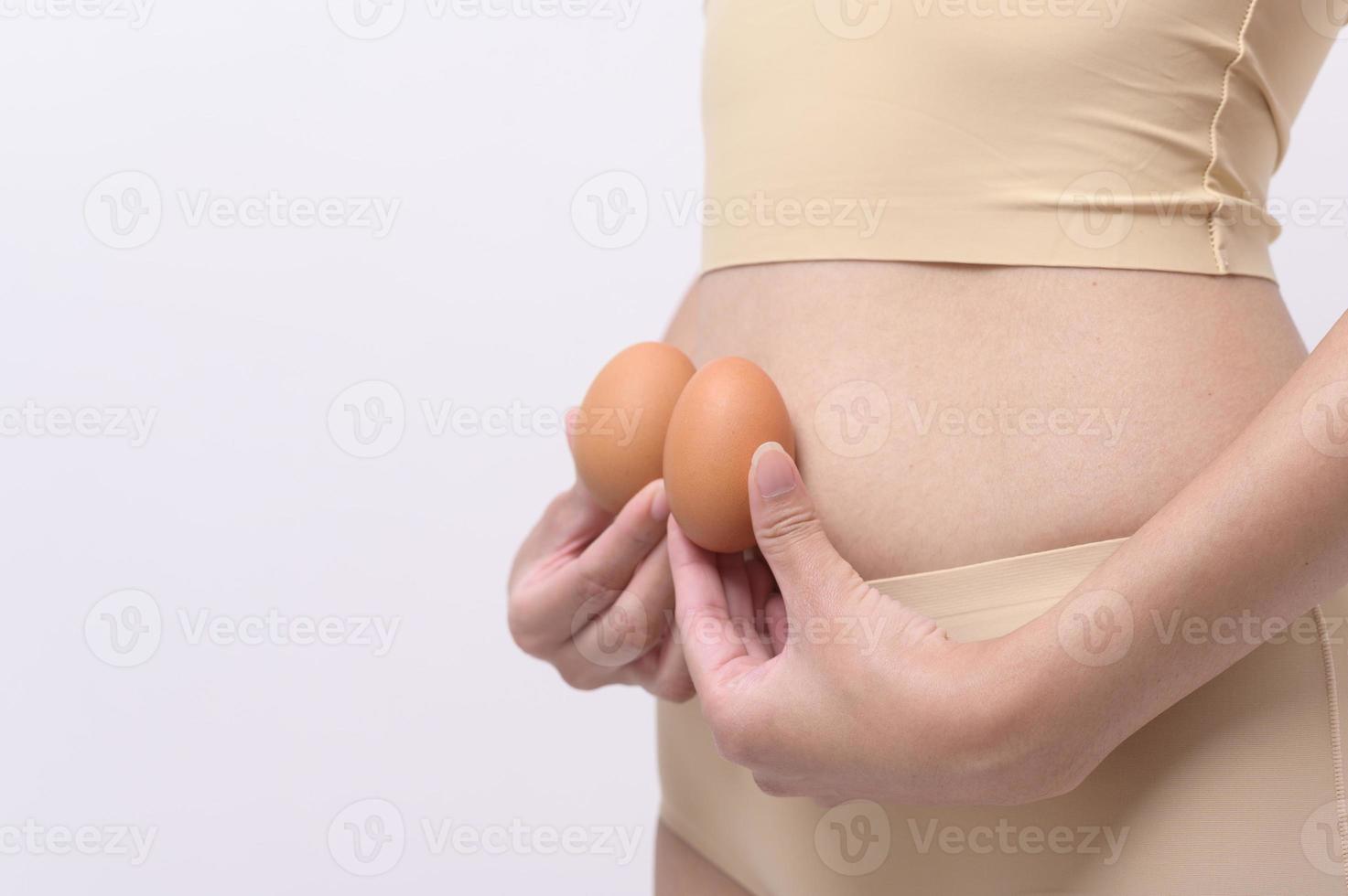 Close up woman holding eggs on belly , prepare reproductive fertility , Ovulation stimulation , matherinty concept photo