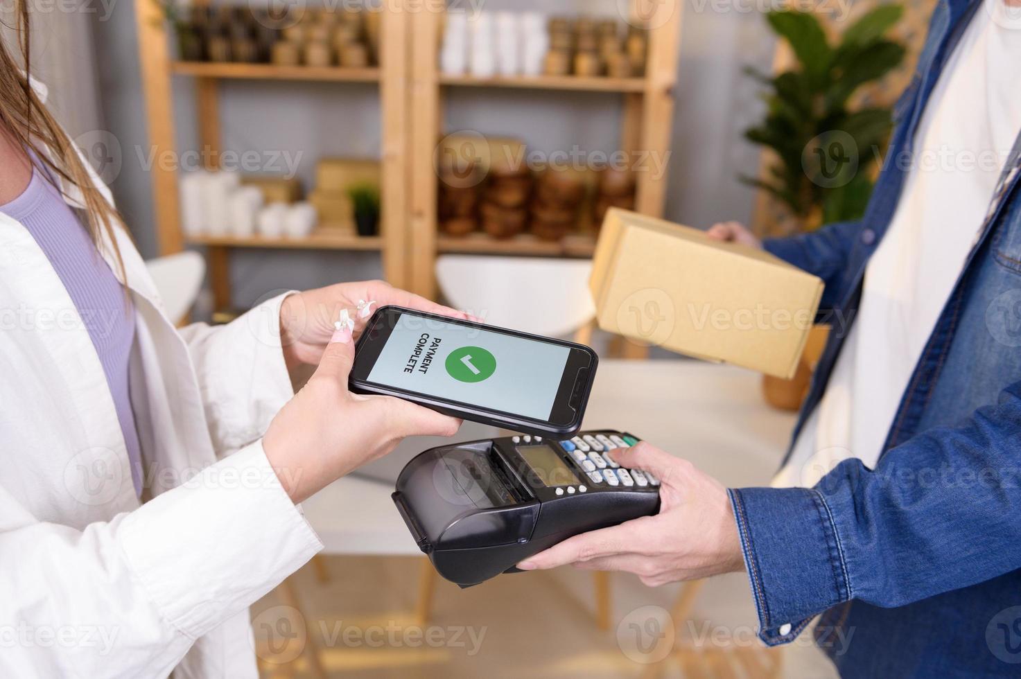 woman customer using QR code payment via smartphone for paying at shop photo