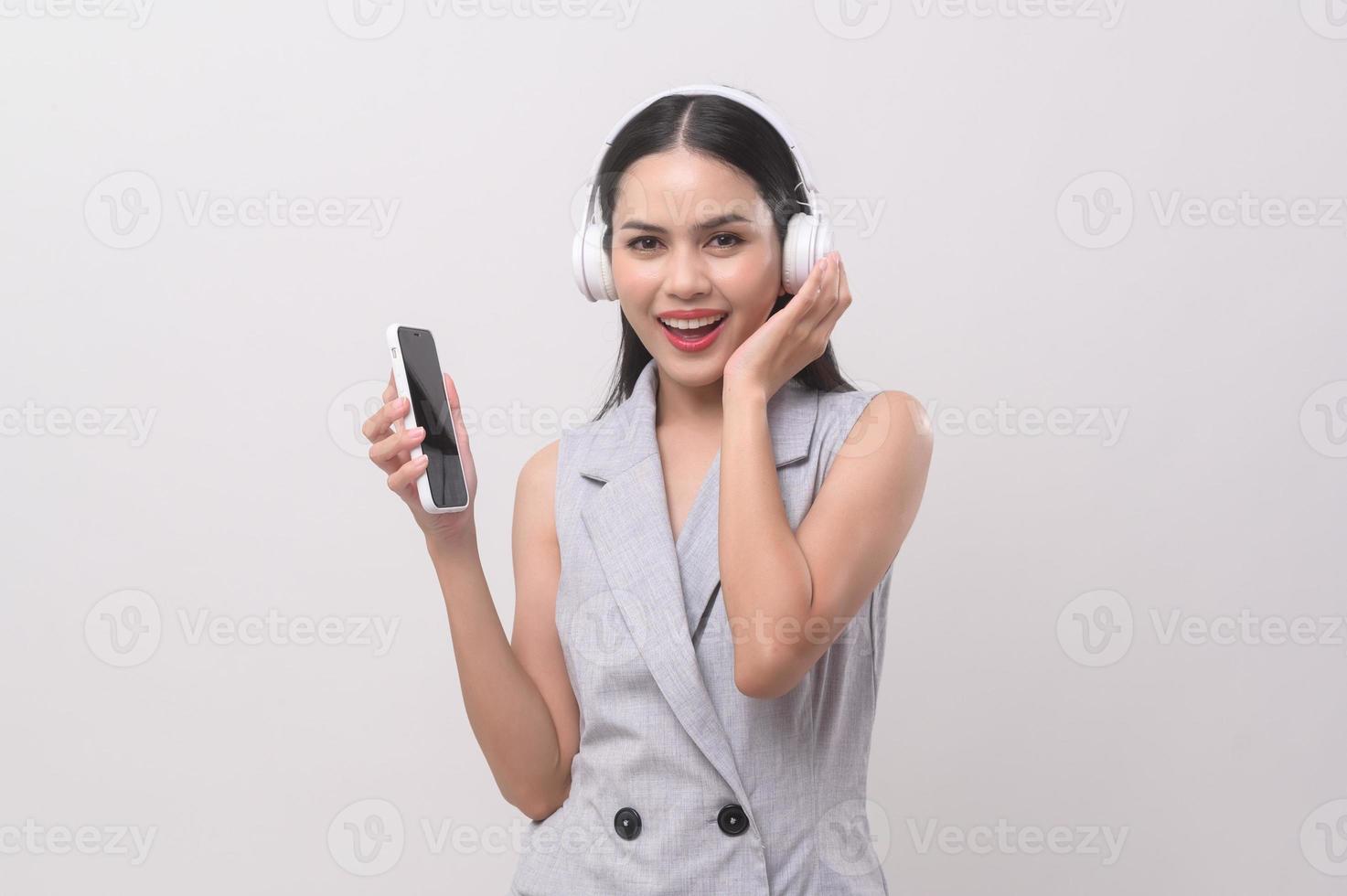 A young woman wearing headphones enjoying with music on white background photo