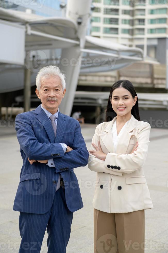 Portrait of Asian senior mature middle aged businessman and young businesswoman in modern city photo