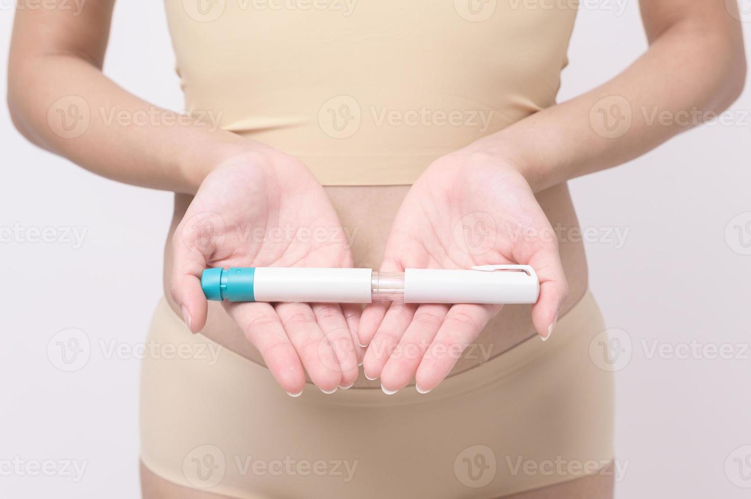Close up woman using IVF treatment injection on belly to prepare reproductive fertility , Ovulation stimulation . photo