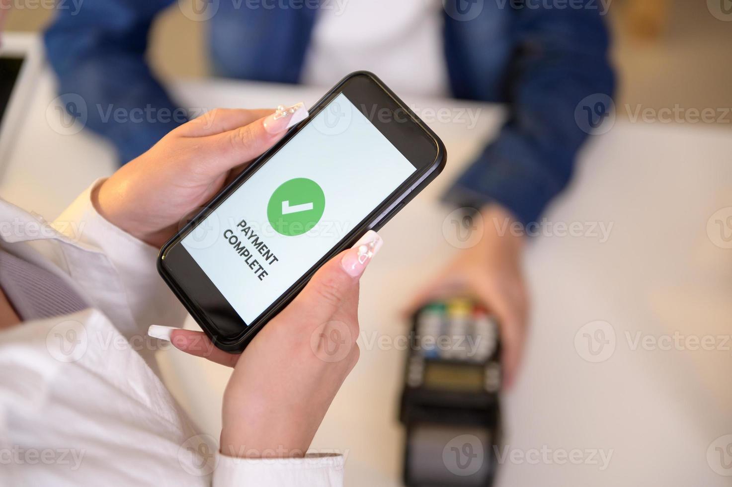 woman customer using QR code payment via smartphone for paying at shop photo