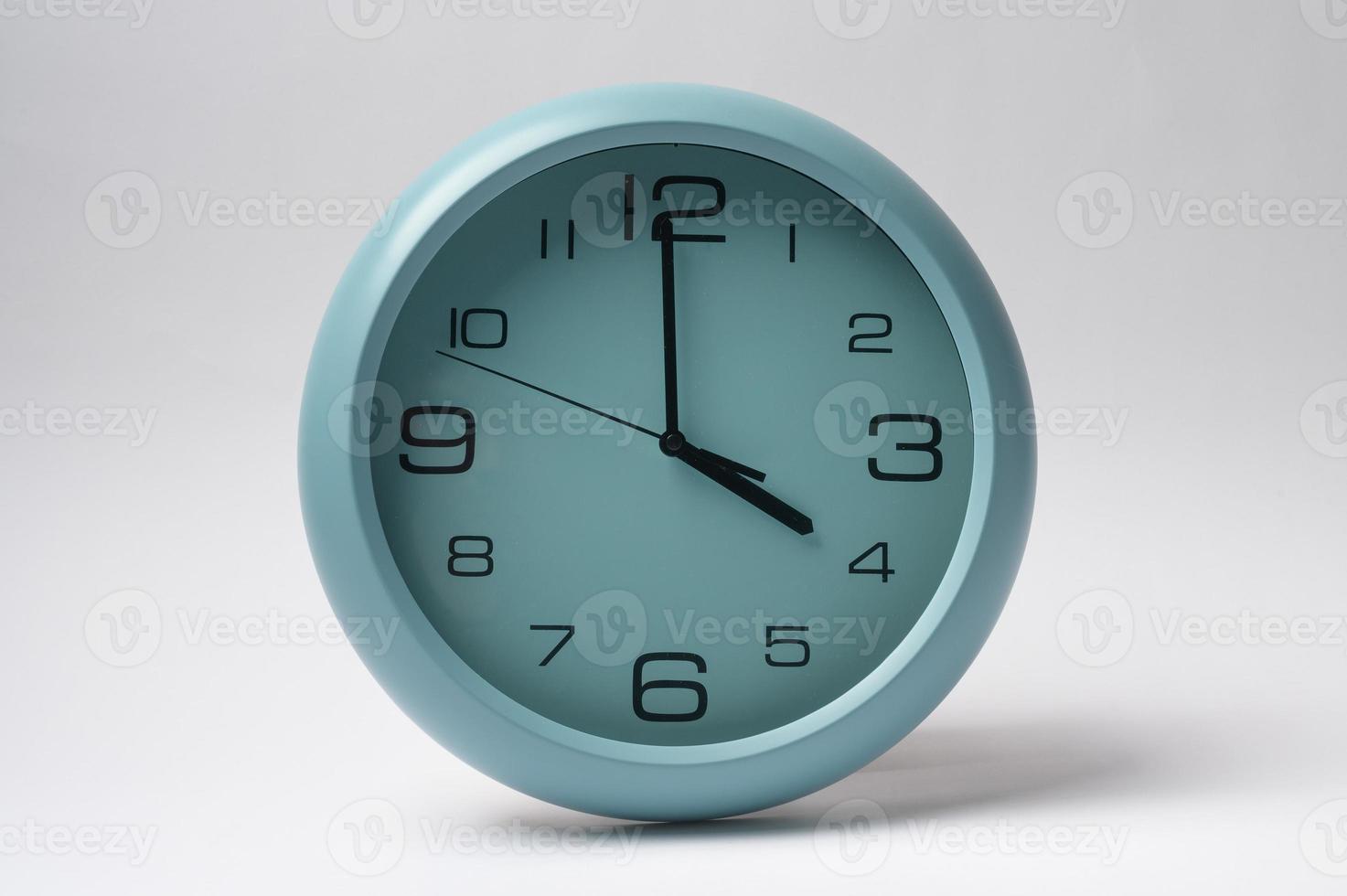 light blue clock hanging on white wall photo