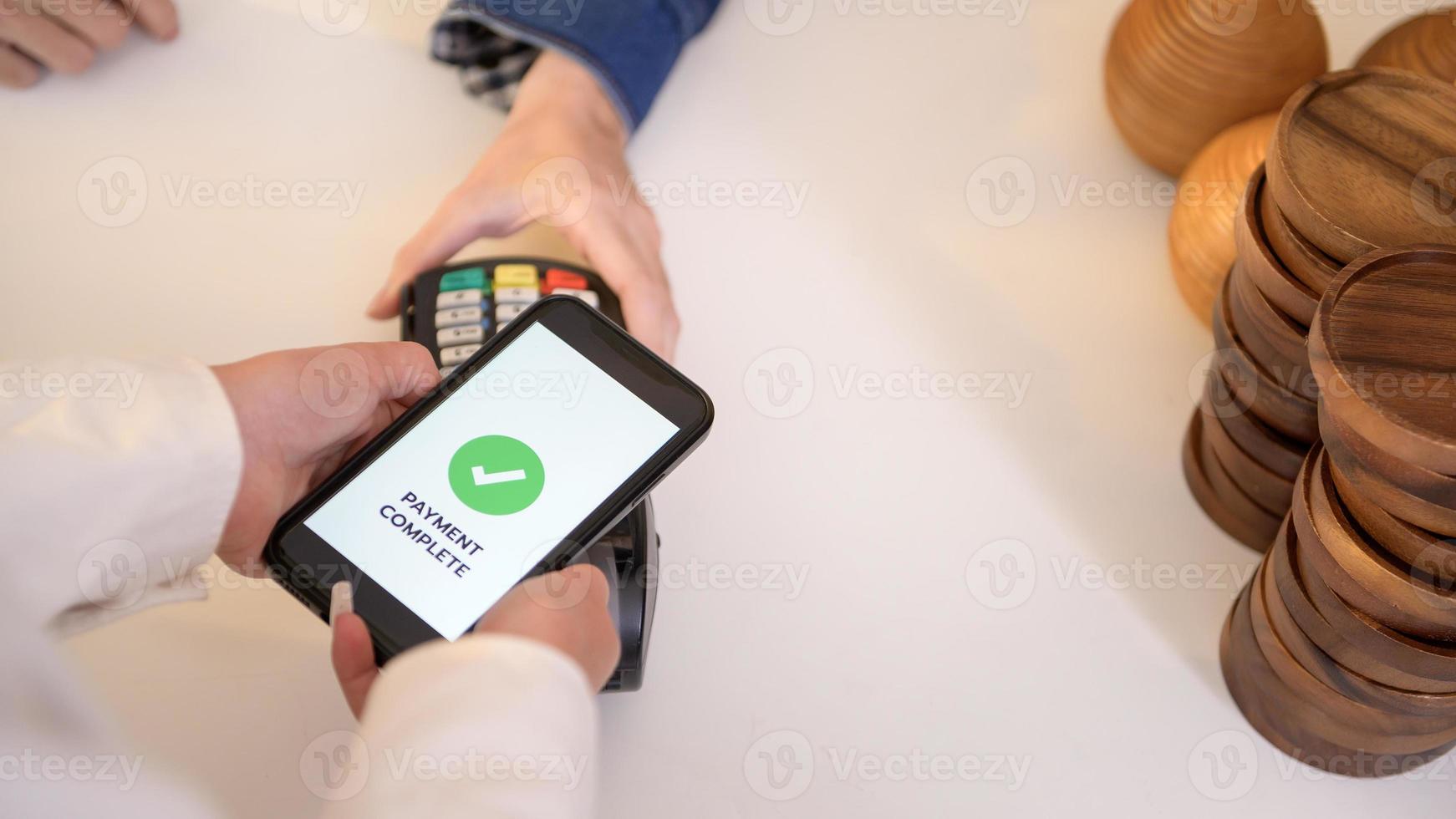 woman customer using QR code payment via smartphone for paying at shop photo