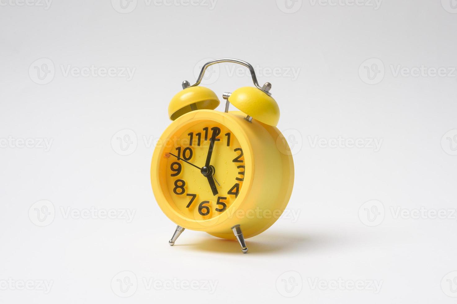 Yellow vintage classic alarm clock over white background photo