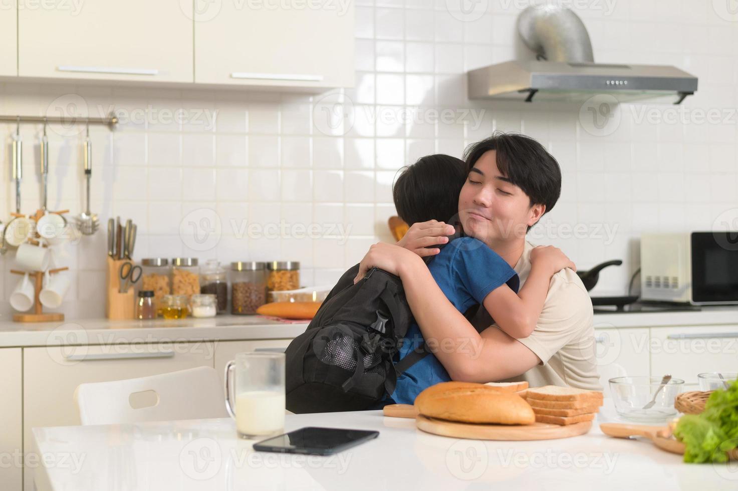 Happy Young Asian father encouraging to his son to go to school photo