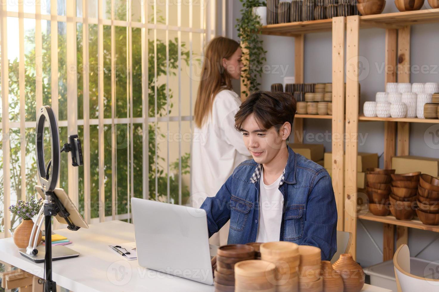 A young couple entrepreneur checking and packaging craft products selling to customers in them shop photo