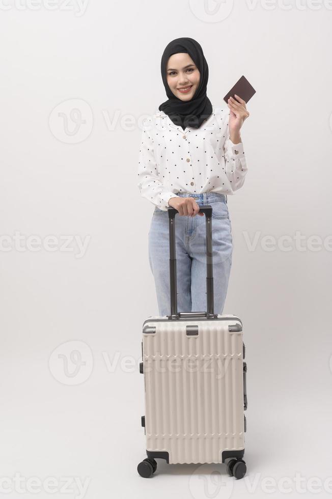 A young muslim woman tourist with baggage  on white background photo