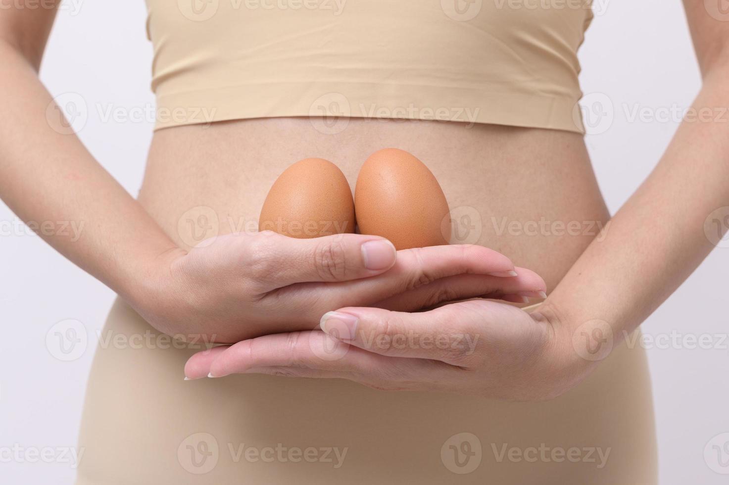 Close up woman holding eggs on belly , prepare reproductive fertility , Ovulation stimulation , matherinty concept photo