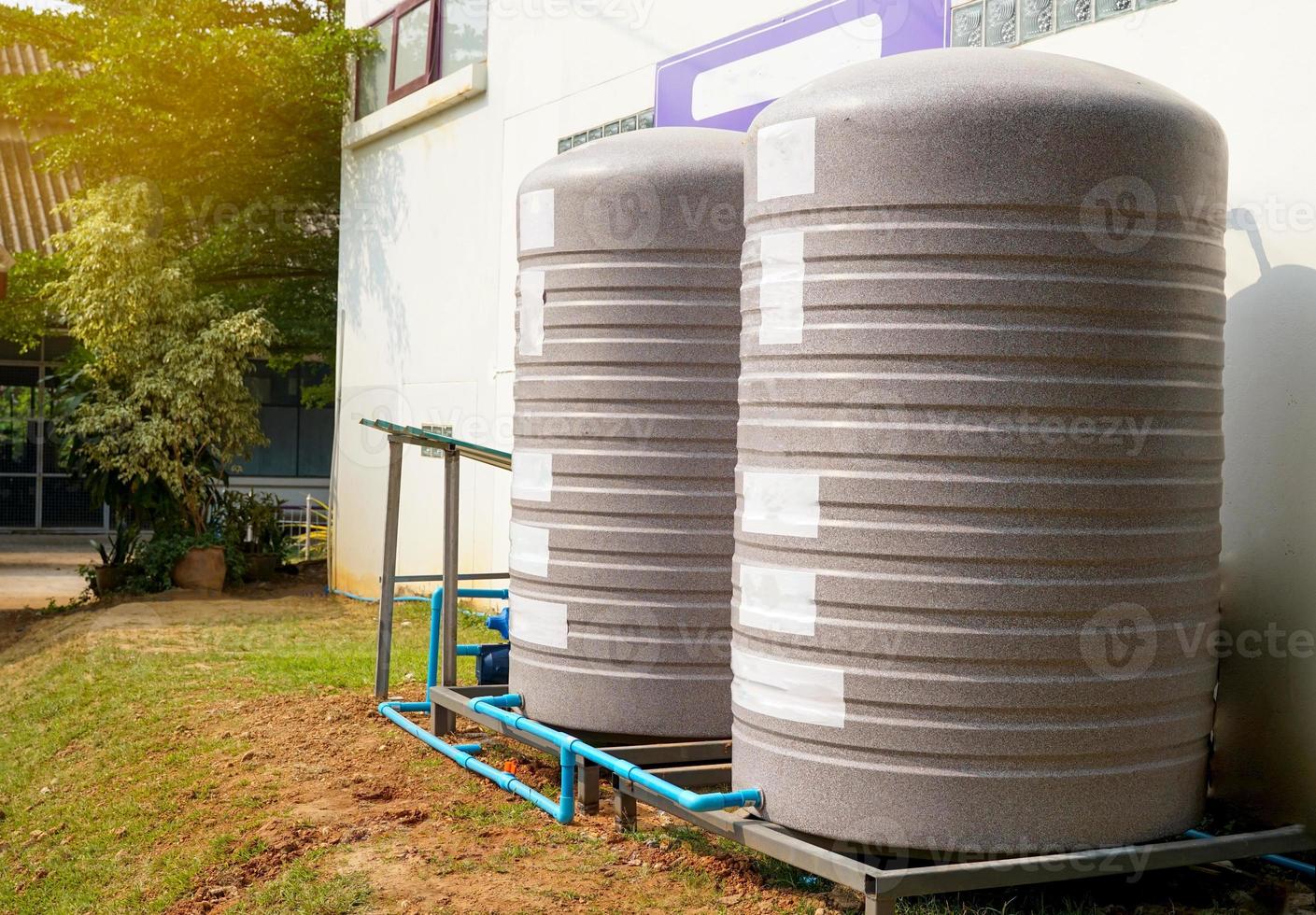 water tank and water pump installed outside the building. For use as a reserve of water for use in homes and offices. Made of special grade material, extra thick, UV protection and not moss. photo