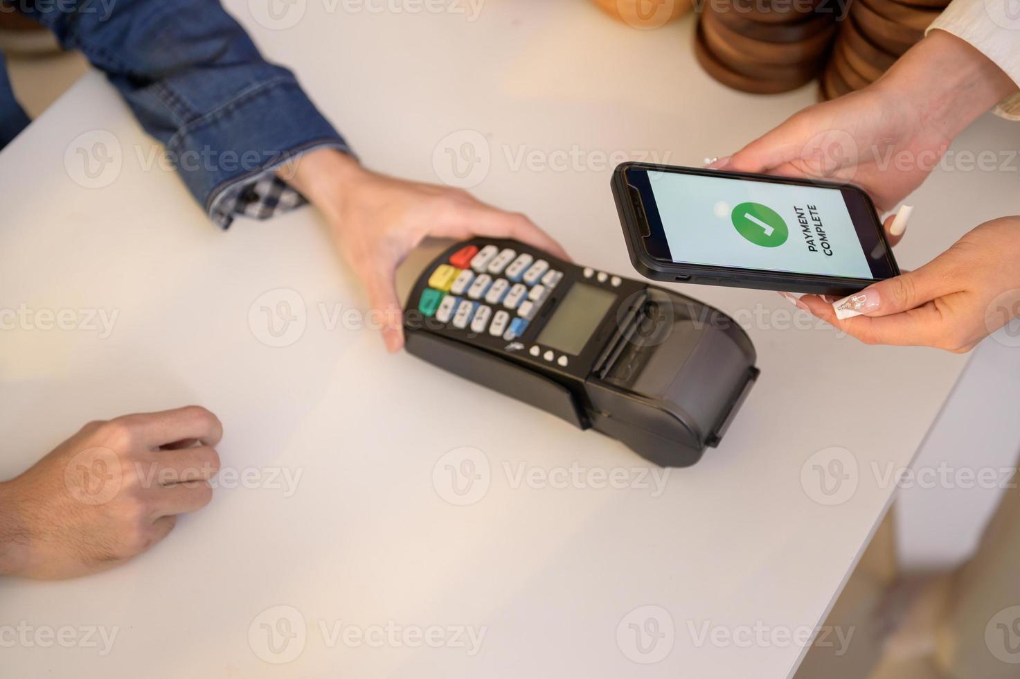 woman customer using QR code payment via smartphone for paying at shop photo