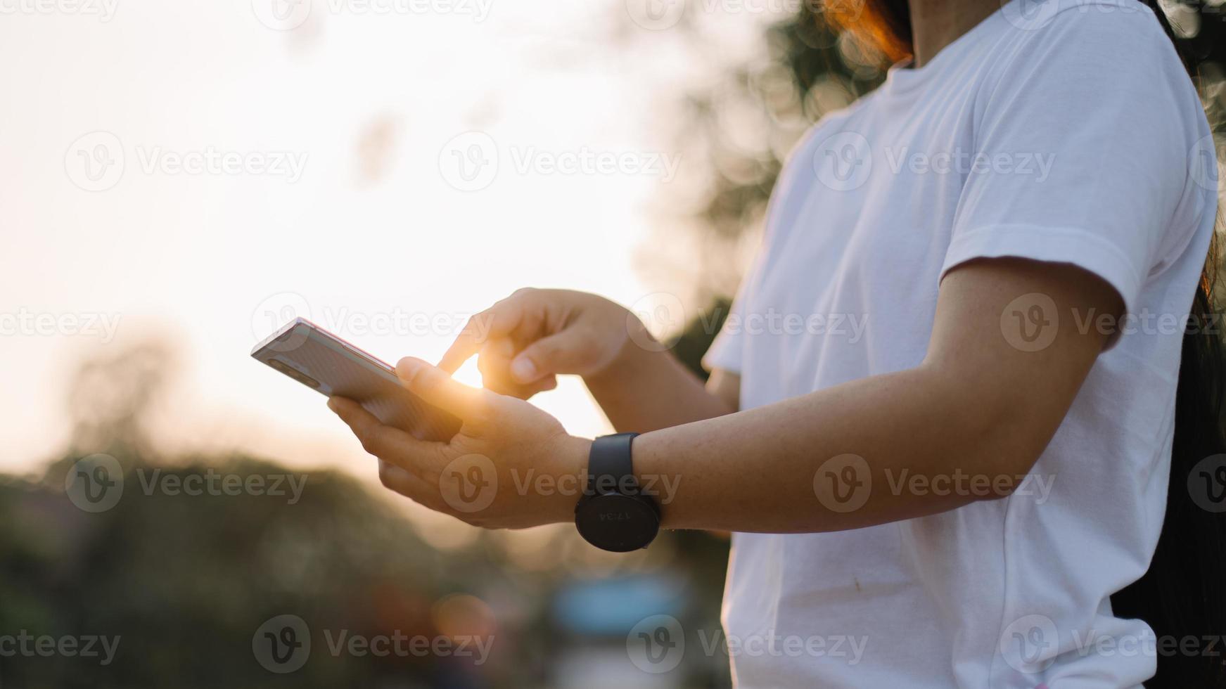 Close up woman hand hold using smart phone on outdoor park street background. Copy space of technology business and travel holiday concept. Vintage tone filter effect color style. photo