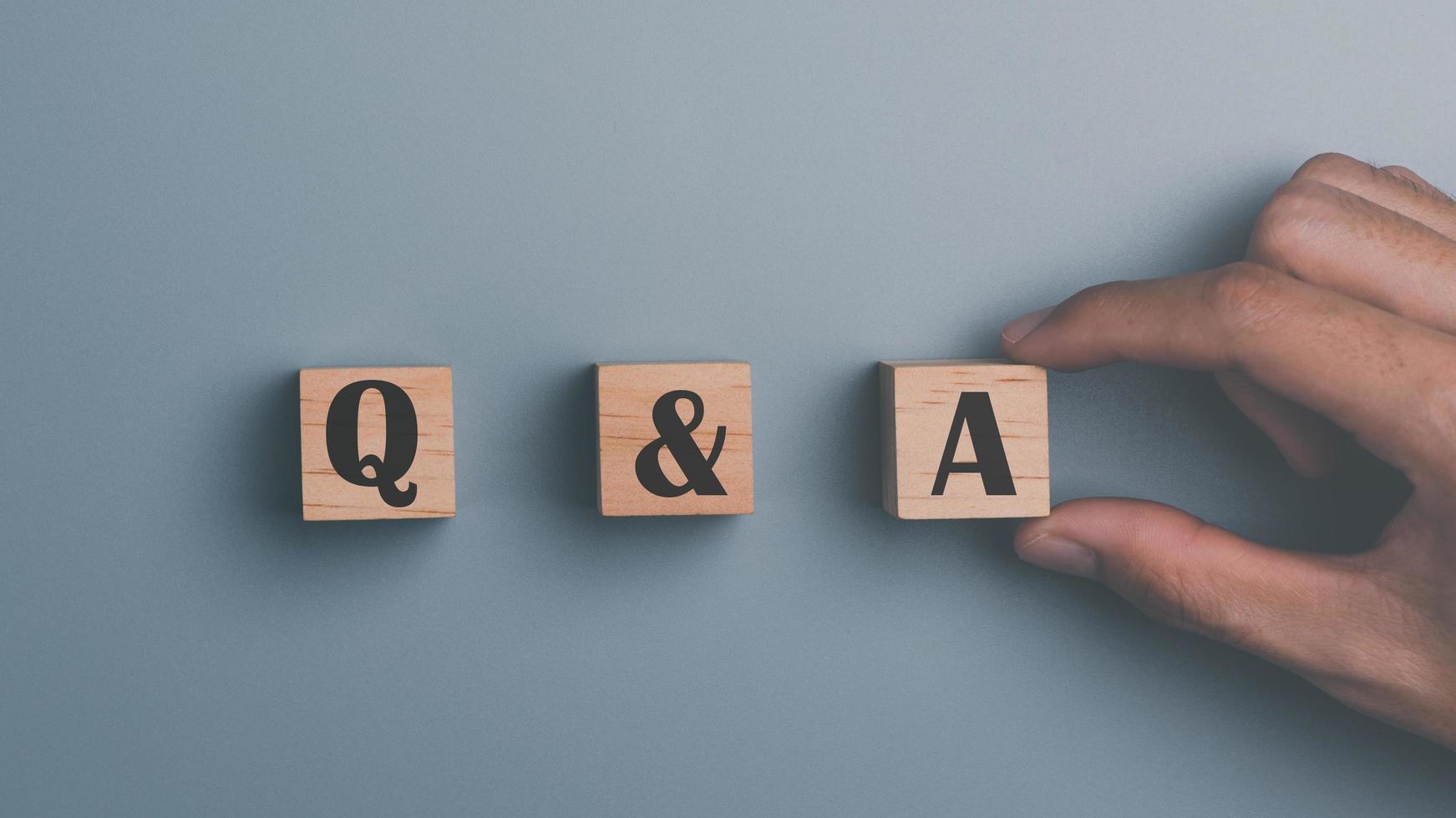 Wooden blocks and human hands ,concepts to find answers ,Question Ask ,getting help in solving problems, Q and A word with wooden cube block ,frequency asked questions photo