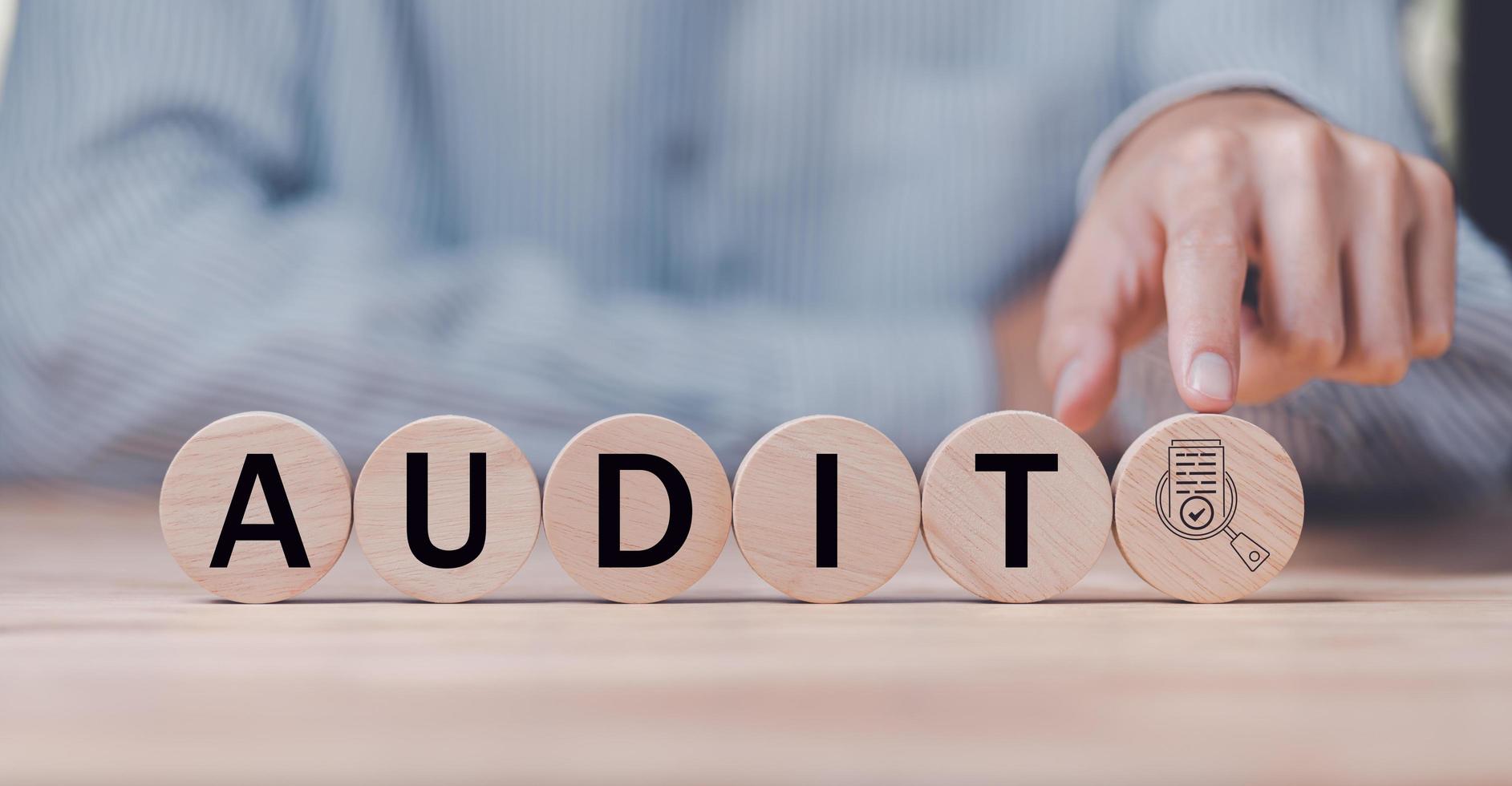 Businessman pointing at a wooden block,Show document audit concept quality assessment with a checklist business document evaluation process ,process of reviewing plans and evaluating their correctness photo