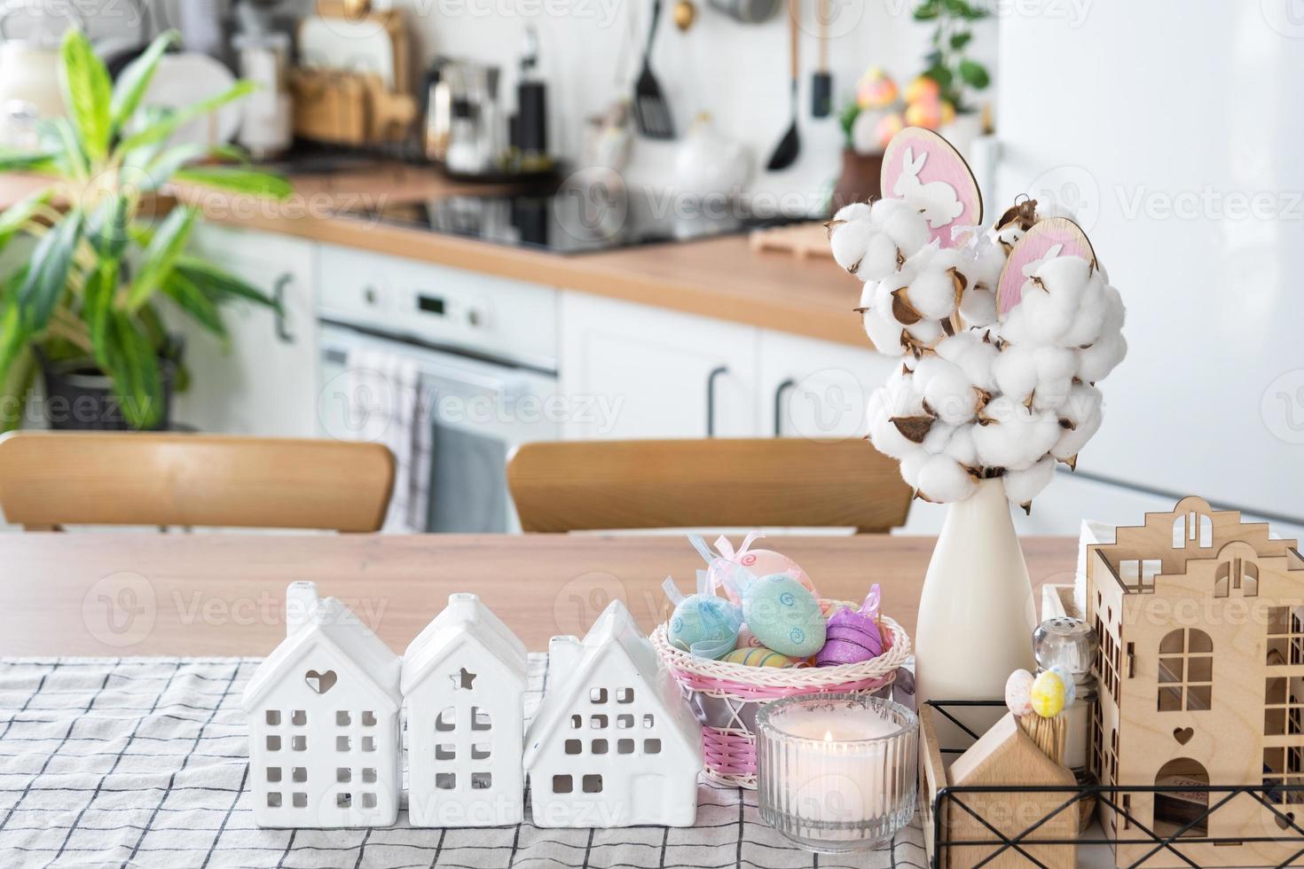 Key to house of cozy home with Easter decor with rabbit and eggs on table of kitchen. Building, design, project, moving to new house, mortgage, insurance, rent and purchase real estate photo