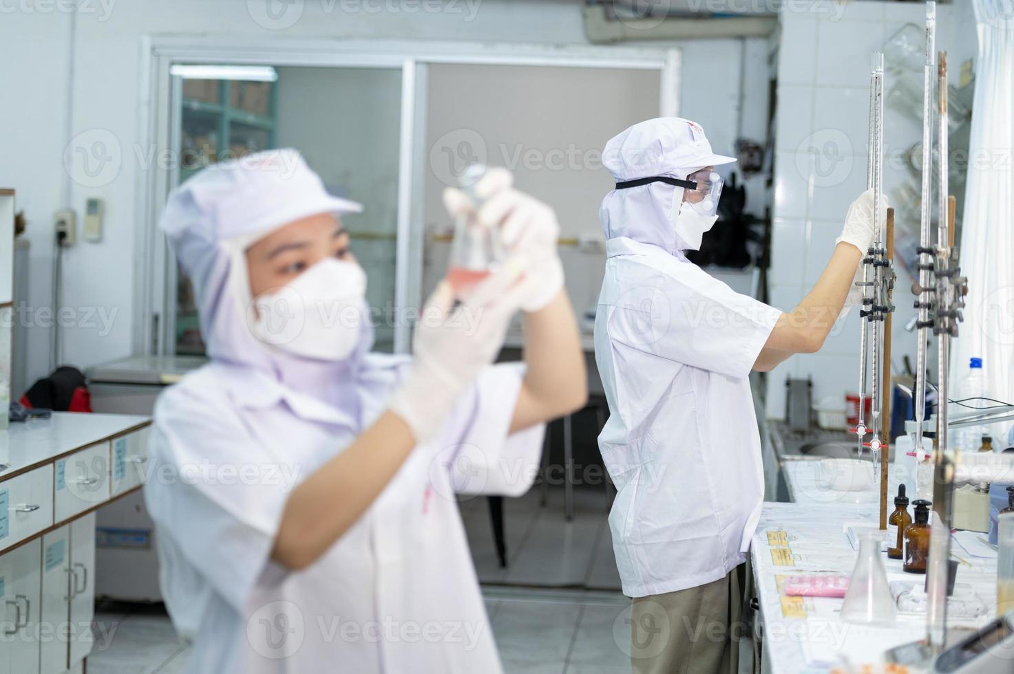 Asian female specialist in quality control lab examining tomato ingredient food in research lab, food industry photo