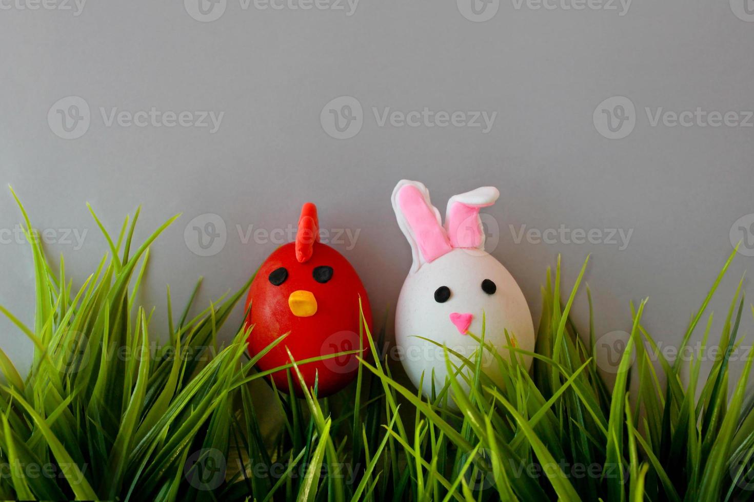 Easter holiday, a handmade egg made by a child in the form of a rabbit and chicken against a grey background photo