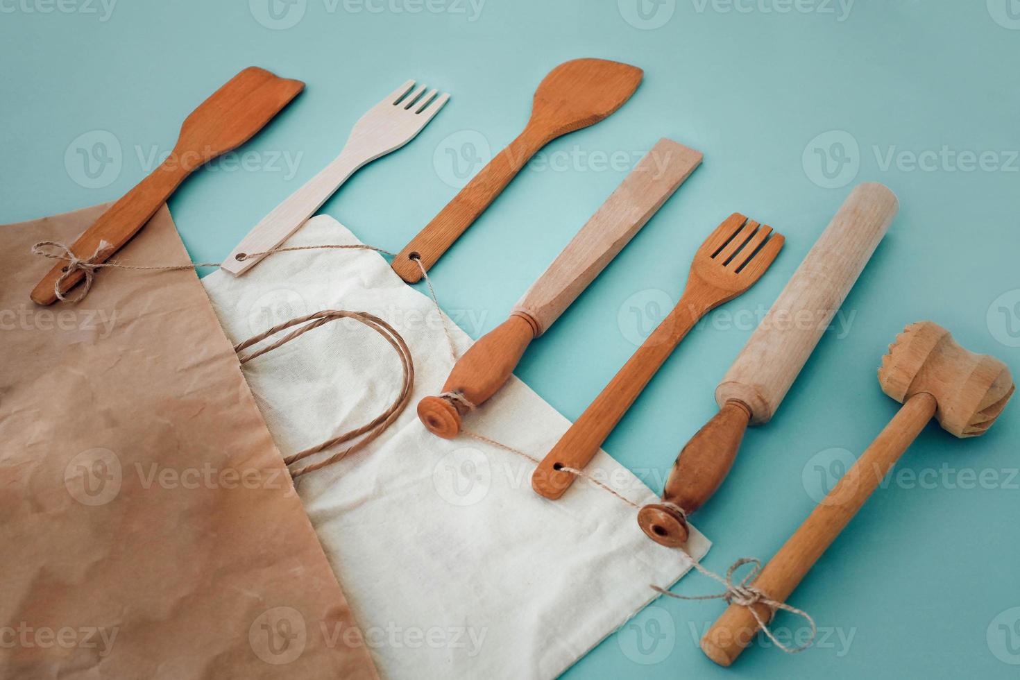 Wooden kitchen utensils hammer, rolling pin, fork, spatula and eco paper bag photo