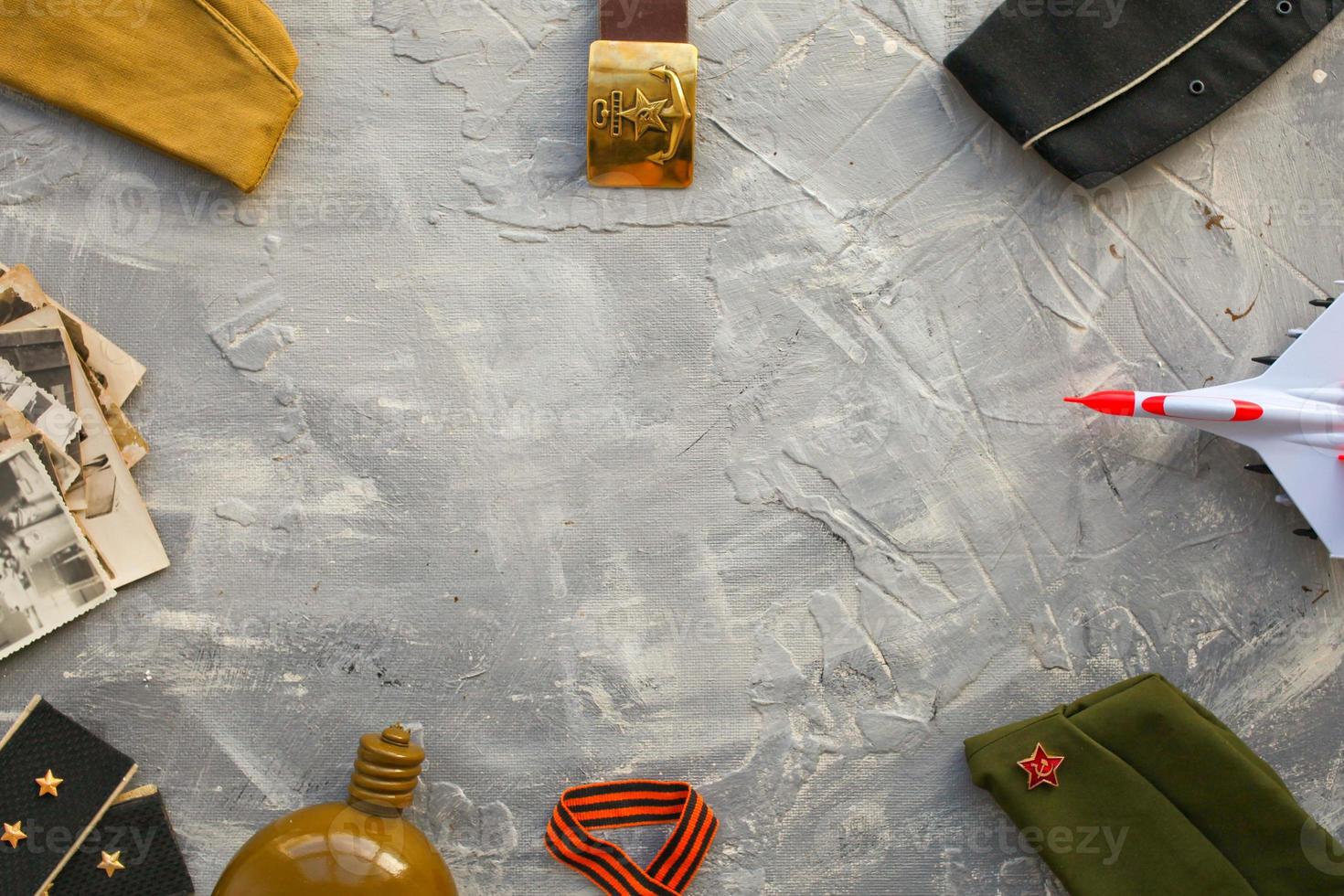 A set of objects on a military theme a flask, shoulder straps, retro photographs, a soldier's belt, an airplan, George ribbon and a cap. Holiday Victory Day, Men's Day photo