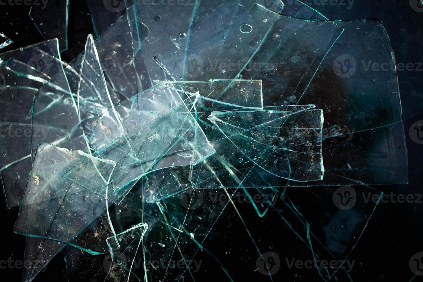 Broken glass pile pieces texture and black background. photo