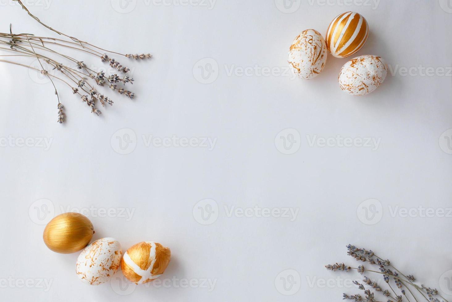 Top view Easter eggs painted with gold paint in various patterns on the sides of lavender. photo