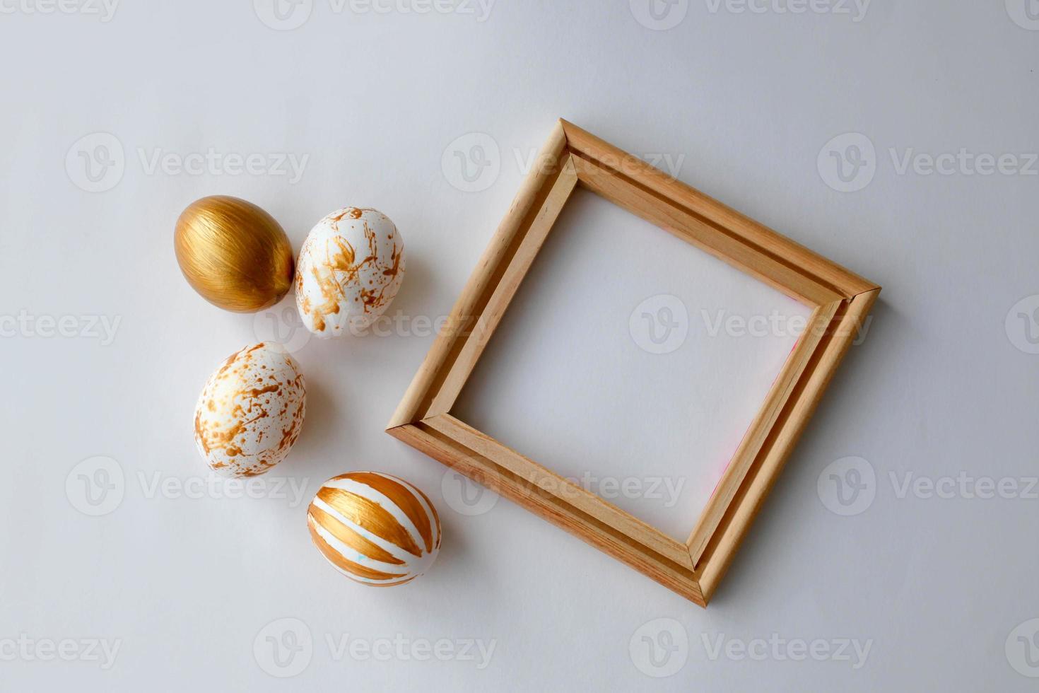 Easter eggs on a gold  and wooden frame background on a white background. photo