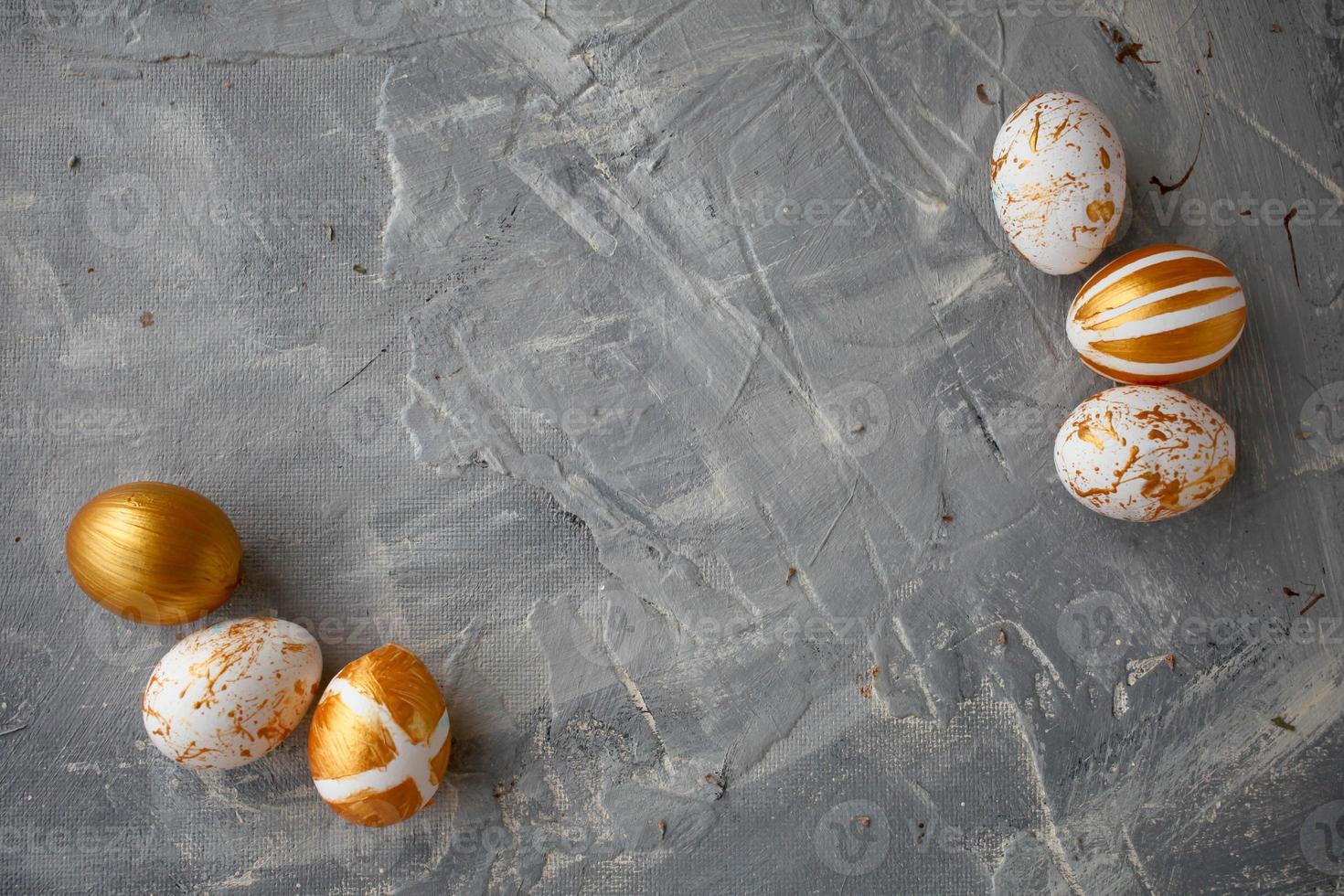 Easter eggs on a gold  and wooden frame background on a grey background. photo
