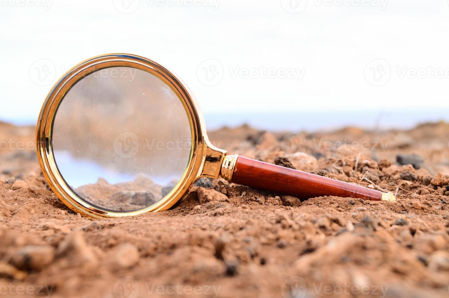 Magnifying glass in the sand photo