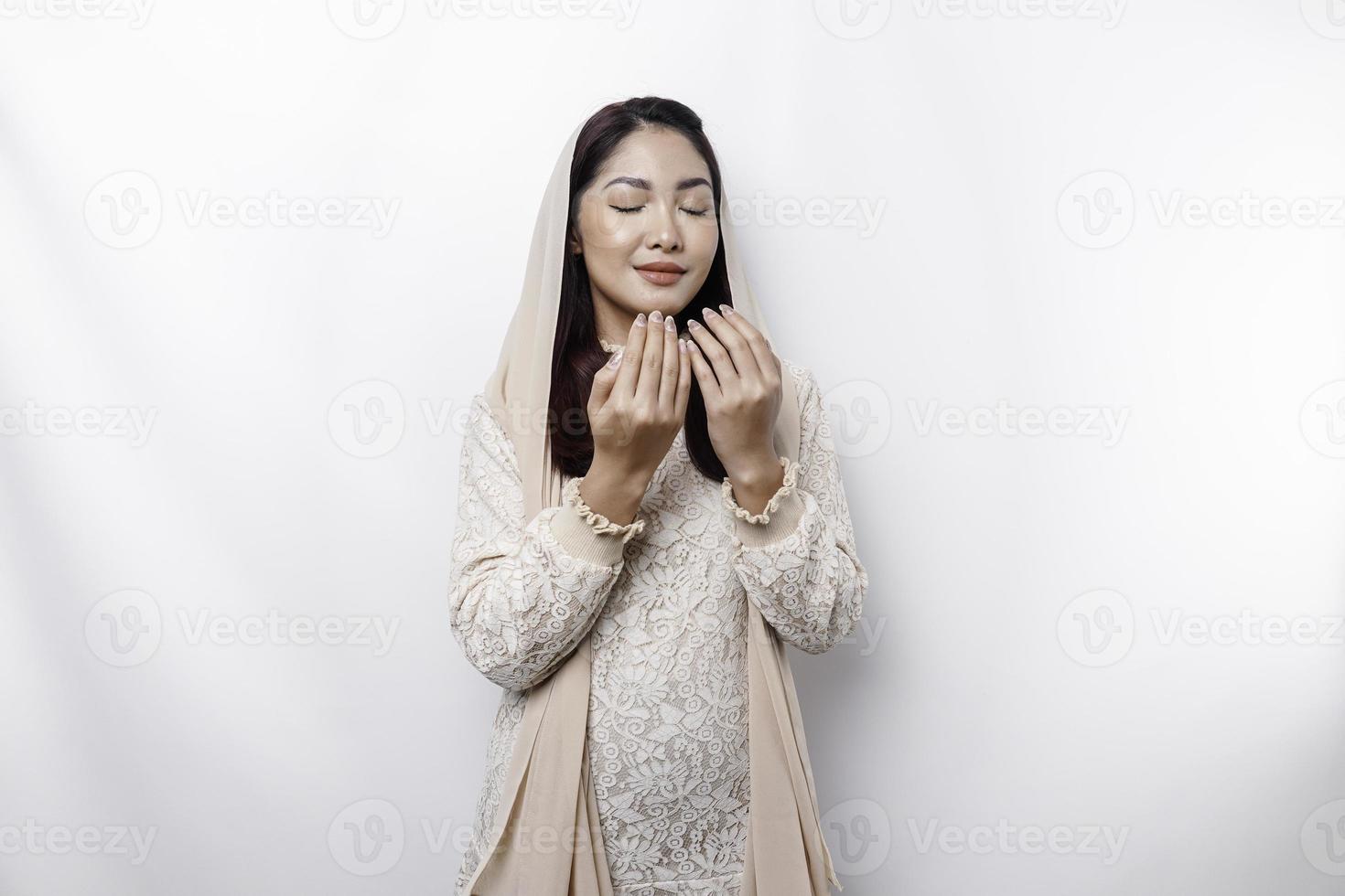 Religious beautiful Asian Muslim girl wearing a headscarf praying to God. photo