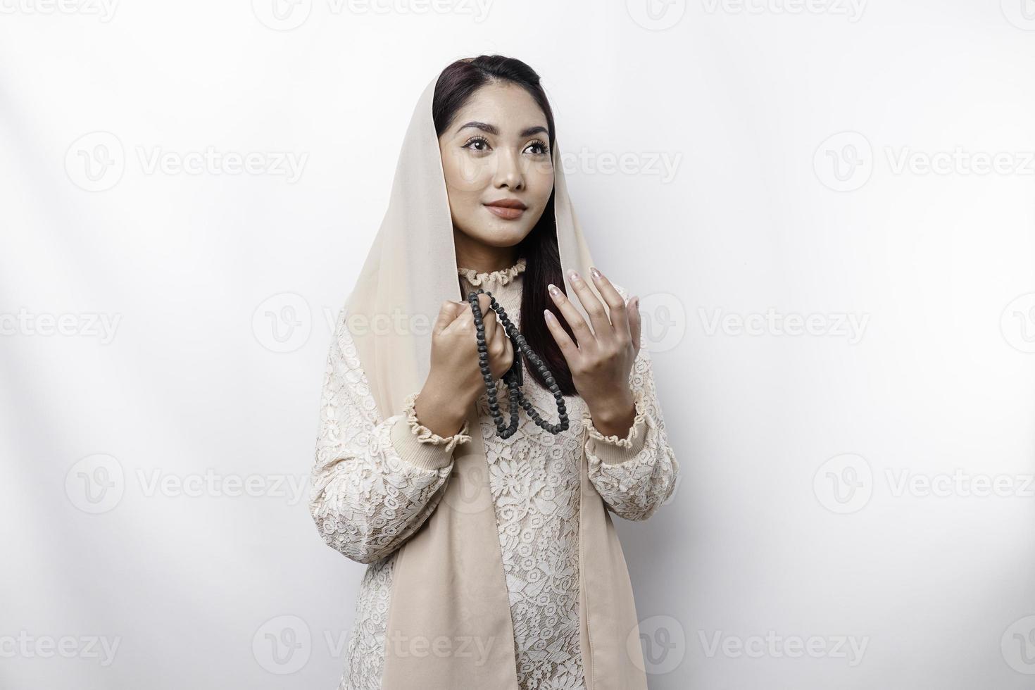 Religious beautiful Asian Muslim girl wearing a headscarf praying to God. photo