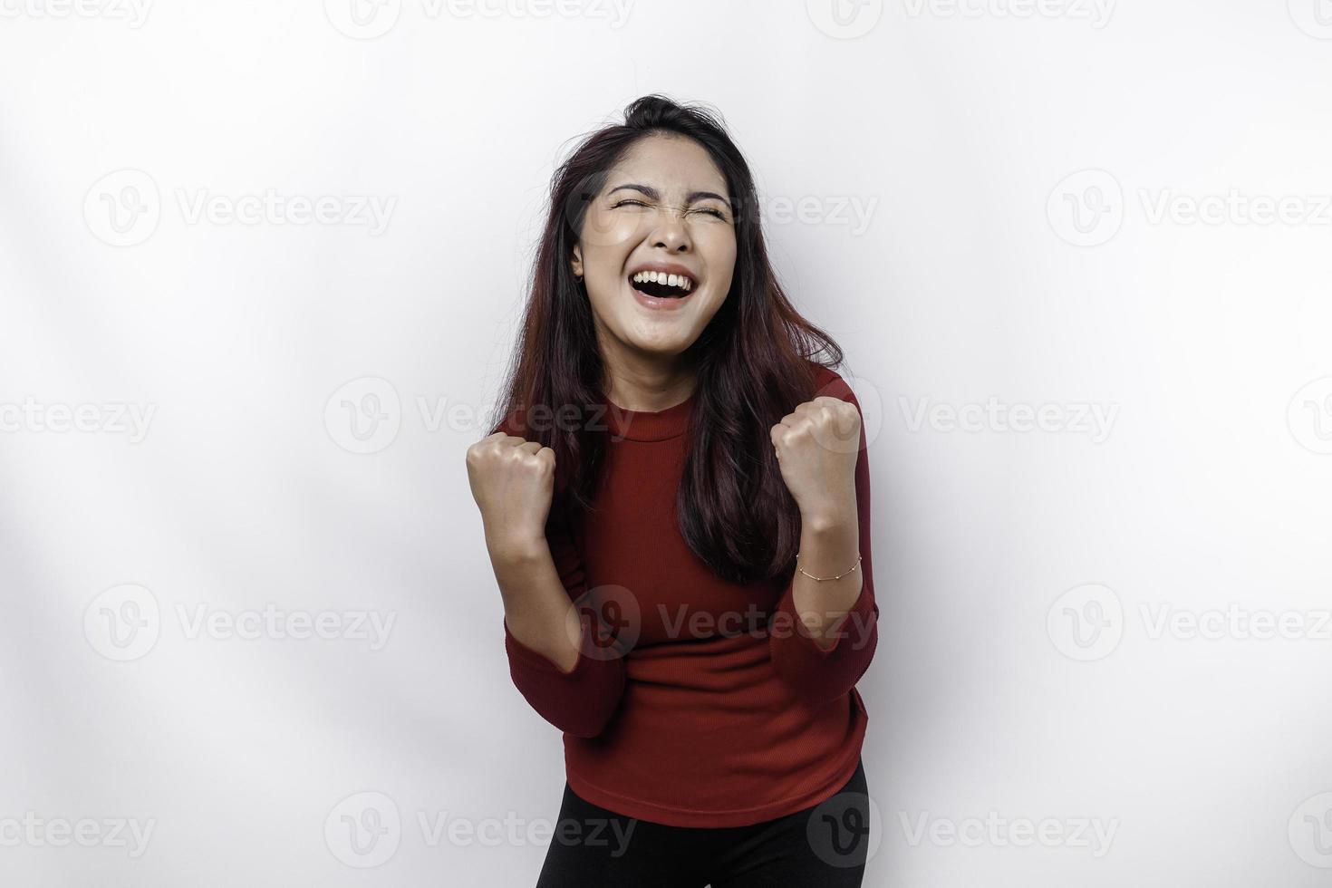 A young Asian woman with a happy successful expression wearing red top isolated by white background photo