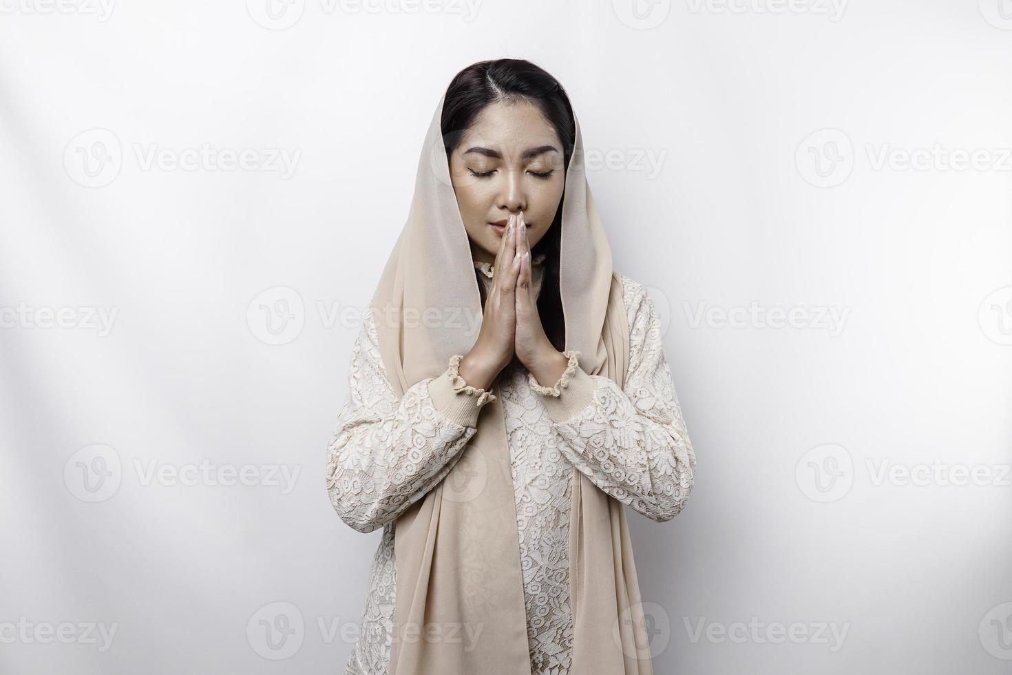 religioso hermosa asiático musulmán niña vistiendo un Pañuelo Orando a dios. foto