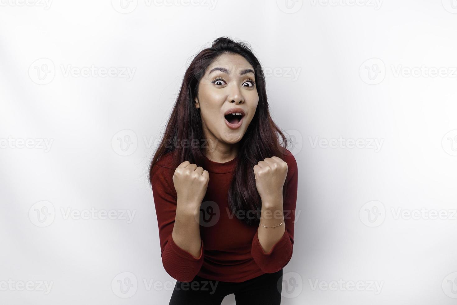 A young Asian woman with a happy successful expression wearing red top isolated by white background photo